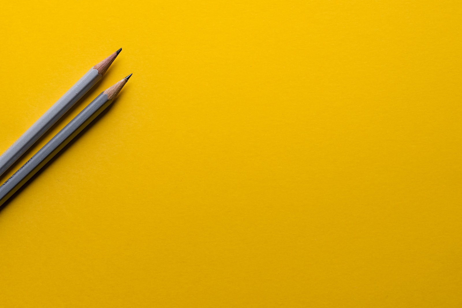 two gray pencils on yellow surface - definition of ready